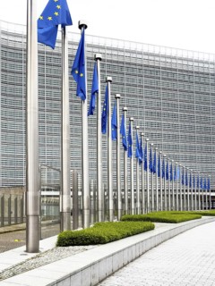 Long row of EU flags in front of the modern glass façade of the Berlaymont building, European