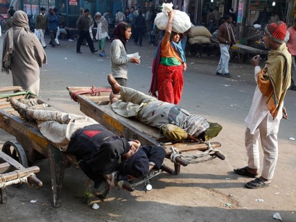 New Delhi, India, 15.01.10 - Market scene, day labourers resting on a sack truck, India