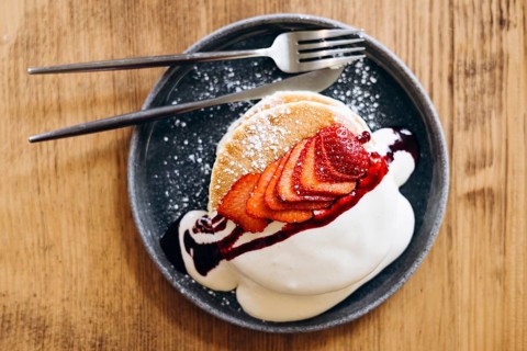 Indulge in fluffy japanese pancakes topped with fresh, juicy strawberries and a dollop of whipped