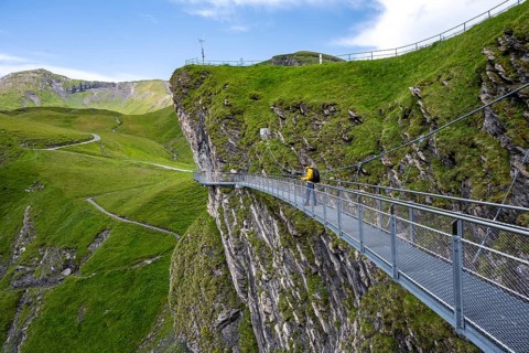 Tourist on First Cliff Walk, metal trail on a rocky outcrop, Grindelwald First, tourist attraction,