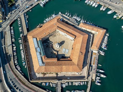 Drone captures of the pentagonal Lazzaretto of Ancona surrounded by harbor waters and boats. This