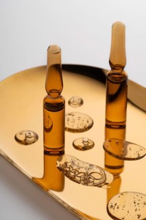 Elegant glass ampoules filled with potent anti-aging serum, showcased on a reflective golden