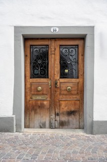 An old wooden door with decorative metal ornaments and a stone door frame in the historic old town