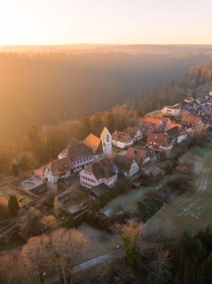 Village with half-timbered houses in a hilly and wooded landscape in the morning light, Zavelstein,