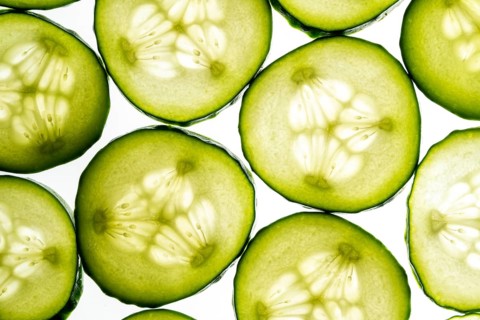 Close up of fresh cucumber slices displayed in a vibrant and visually appealing pattern. The