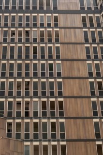 A pattern of windows of an abandoned high rise building, a dated architectural style with