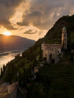 A breathtaking sunset over Morcote, Switzerland, capturing the serene view of a historic church