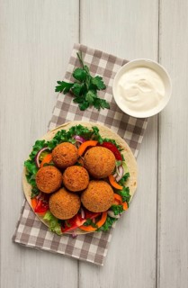 Tortillas, wrapped falafel balls, with fresh vegetables, vegetarian healthy food, on a wooden white