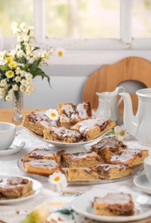 Homemade cake with icing on a table set with flowers in spring