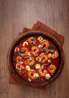 Saganaki with shrimp, in a clay pan, Greek dish, shrimp in tomato sauce, feta cheese, homemade, no