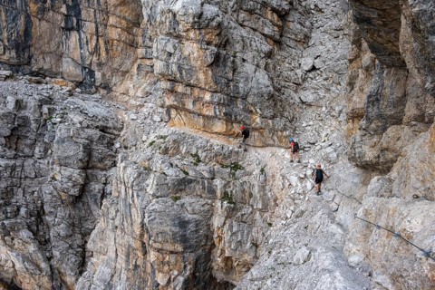 Three hikers on the Via Ferrate Benini via ferrata on a cliff, Brenta Mountains, Parco Naturale