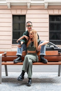 A Colombian lesbian couple sits close on a bench, embodying love, identity, and diversity. Their