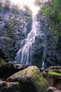 Close-up of a waterfall flowing over steep rocks in a forest, Burgbach Waterfall, Bad