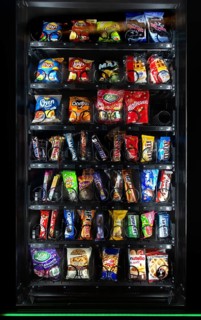Snack vending machine, snack dispenser selling colourful sweets and chocolate bars in public place