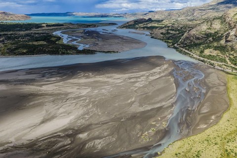 Sandbank in the river Rio Ibanez short before flowing into lake Lago General Carrera, steep road