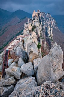 View of stones and rock formations from Ulsanbawi rock peak in stormy weather with clouds.