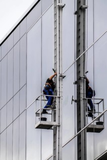 Window cleaner, facade cleaning, window cleaning, on a glass facade in Düsseldorf, ladder cage from