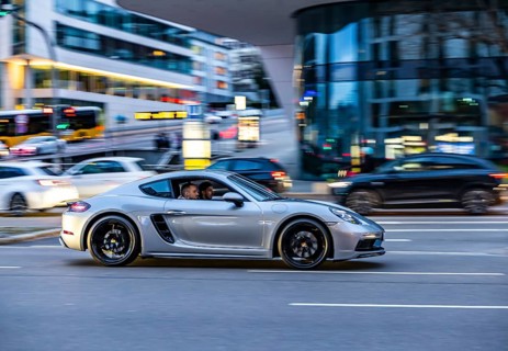 Car at night in front of an urban environment with modern architecture, driver. Porsche. Stuttgart,
