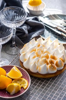 A beautifully styled scene with a homemade lemon cake, fresh lemon slices, and elegant glassware on