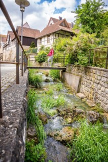 Small bridge in the town centre with woman in red jacket, Balingen, Germany
