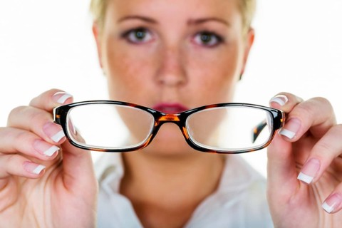 A blonde woman gets new glasses, symbolic photo for poor vision and defective vision, dioptre