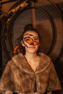 Halloween party with friends in a disco nightclub, portrait of a woman with a painted face with red