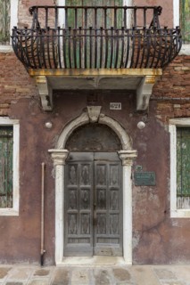 Dilapidated house façade with front door and wrought-iron balcony, Burano, Venice, Veneto, Italy