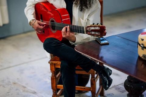 Anonymous Latin man playing red bass guitar in studio