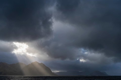 Sunbeams over coastal landscape and sea, Lofoten, Nordland, Norway, September 2020