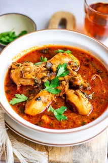 Close-up of a flavorful chicken stew featuring tender pieces simmered in rich tomato sauce,