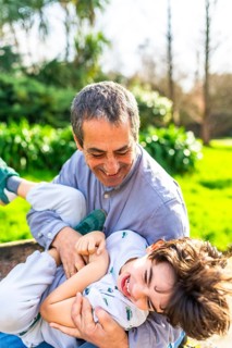 Grandfather and grandson enjoying a playful moment together in a park, creating cherished memories