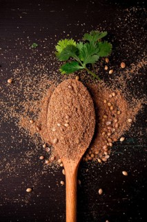 Fresh cilantro, coriander grains and powder, on a wooden table, top view, no people