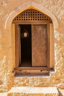 Decorated round arch entrance door in the largest preserved mud town in Oman, Al Bilaad, Al Bilaad