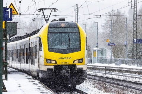 Regional train from Arverio on its way through a winter landscape in snowfall. The railcar train is