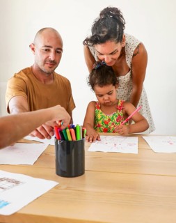 A family spends quality time drawing together at the table, highlighting the importance of