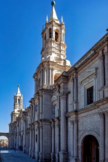 Impressive church tower against bright blue sky, impressive stone architecture, The Basilica