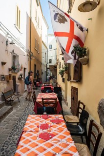 Picturesque alley and Sardinian flag, old town centre, Castelsardo, Sardinia, Italy