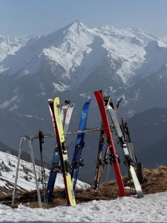 Ski touring, skiing standing on a ski rack in front of a hut, wintry mountain landscape,