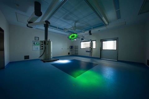 Operating room with green lighting, dark ambiance and modern equipment, operating room in the new