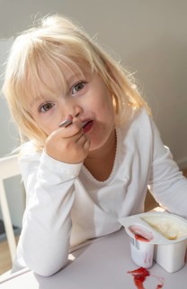 Portrait of blonde girl, 3 years old, having lunch in Ystad, Skåne County, Sweden, Scandinavia