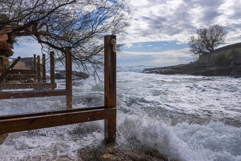 Wooden walkway destroyed by the sea, east coast in Cala Ratjada, Majorca, Spain