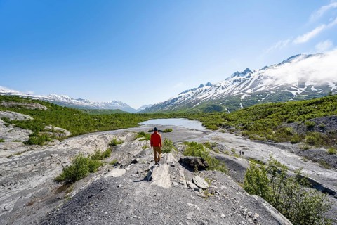 Hikers on glacial moraine, view of the vast Tsina River valley with mountains, Worthington Glacier