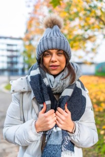 Vertical portrait of a beauty woman with warm clothes in a park in autumn