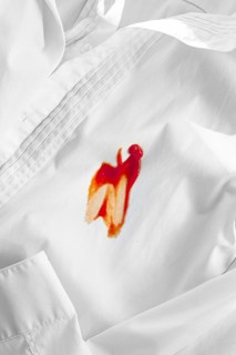 White shirt stained with ketchup, no people, close-up, selective focus