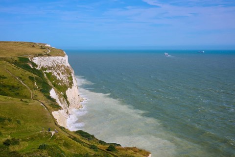 View of cliffs and sea with boats on horizon under clear sky, summer, chalk cliffs, English