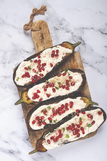 Fried eggplant with sauce, decorated with microgreens and pomegranate seeds, eggplant appetizer,