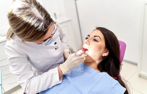 A dental professional examines a patient in a modern clinic, using specialized tools to ensure oral