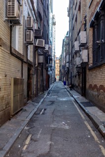 Narrow, functional alleyway between air-conditioned brick walls, Liverpool
