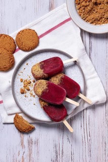 Top view of vibrant raspberries and cookies flavored ice pops served on a metal tray, surrounded by