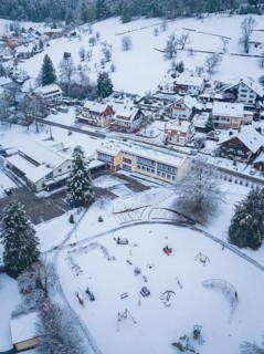 Snow-covered playground and school building in a small village, Enzklösterle, district of Calw,